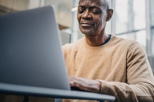 在大街上的笔记本电脑上工作的成熟商人 · 免费素材图片