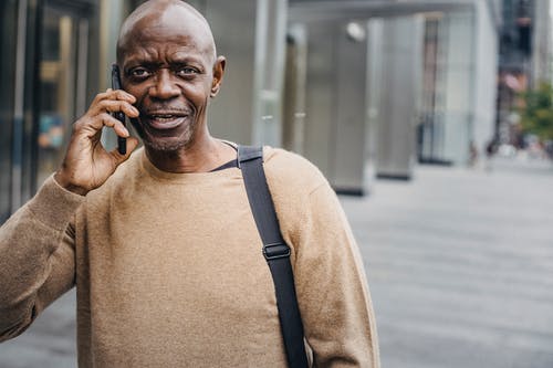 秃头黑人谈街上的智能手机 · 免费素材图片