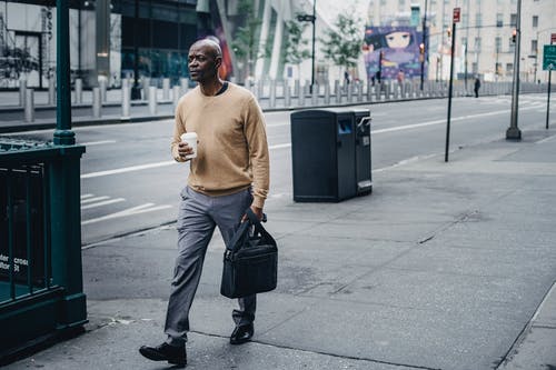 严重的黑人男子，在咖啡的人行道上行走 · 免费素材图片