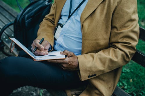 在公园里在记事本中作物不露面黑人商人写作的想法 · 免费素材图片