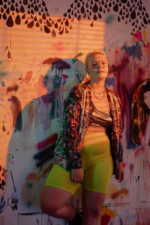 黑色和红色羊毛衫站在涂鸦墙旁边的女人 · 免费素材图片