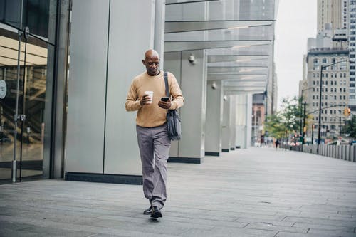 优雅的黑人男子，在市中心的咖啡和电话 · 免费素材图片