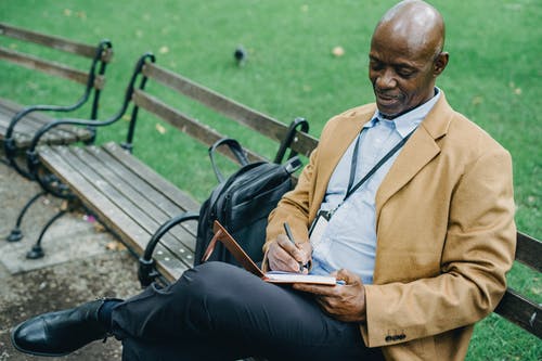 在公园里的笔记本上写的积极黑人 · 免费素材图片