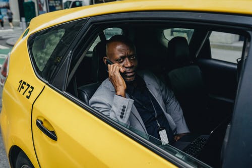 思考黑人商人乘坐出租车和谈到智能手机 · 免费素材图片