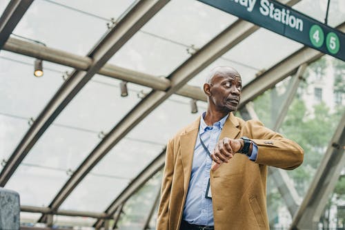守时的黑人男子，检查在地铁站的手表上的时间 · 免费素材图片