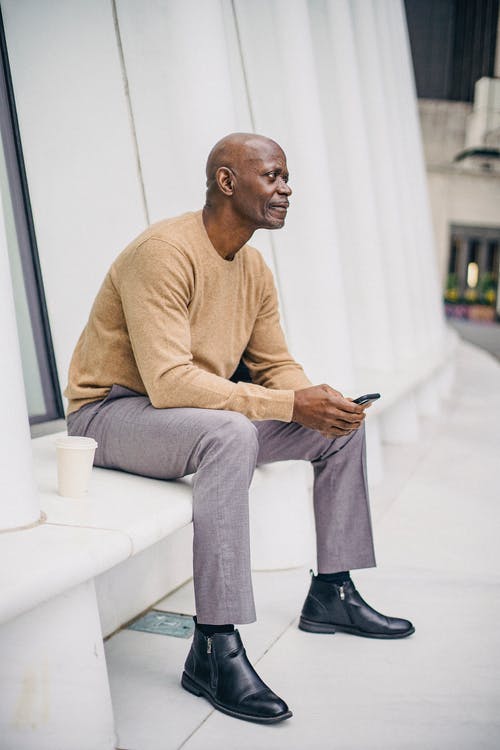 在智能手机上的长凳上平静成熟的族裔男性企业家传讯 · 免费素材图片