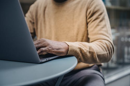 播种时髦的非洲裔美国人，在街边咖啡馆使用便携式计算机 · 免费素材图片