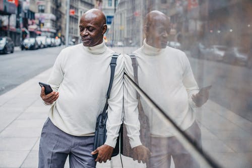 与手机在城市街道上的黑商人 · 免费素材图片