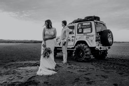 穿着正式服装的新郎和新娘站在沙地上 · 免费素材图片