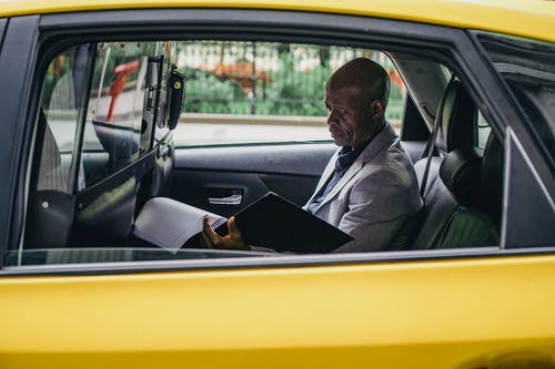 沉思的黑人企业家审查汽车重要报告 · 免费素材图片