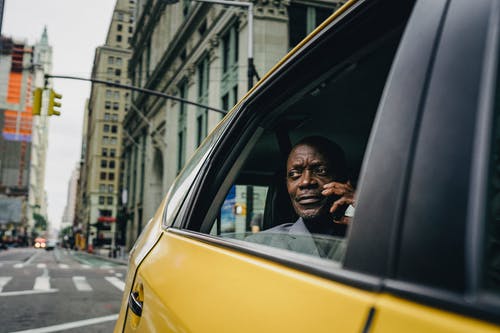 坐在一辆黄色汽车的窗户旁的男人 · 免费素材图片