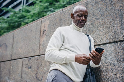 在大街上使用手机的黑人男子 · 免费素材图片