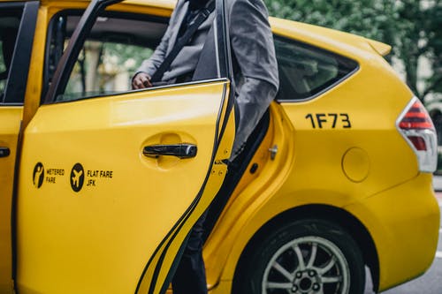 黑人男子在黄色出租车的优雅西装开门 · 免费素材图片