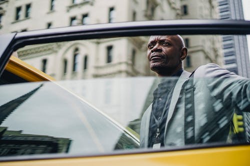 思考打开出租车门的黑人男子 · 免费素材图片