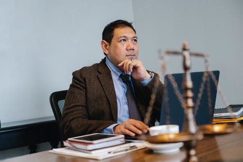 研究膝上型计算机的亚裔男性法官在办公室 · 免费素材图片