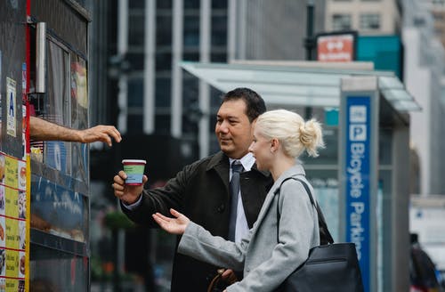 买咖啡的不同同事在休息期间去街上 · 免费素材图片