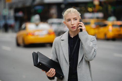 集中女商人谈街上的智能手机 · 免费素材图片