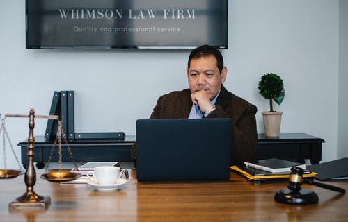 亚洲律师在司法尺度附近使用笔记本电脑 · 免费素材图片
