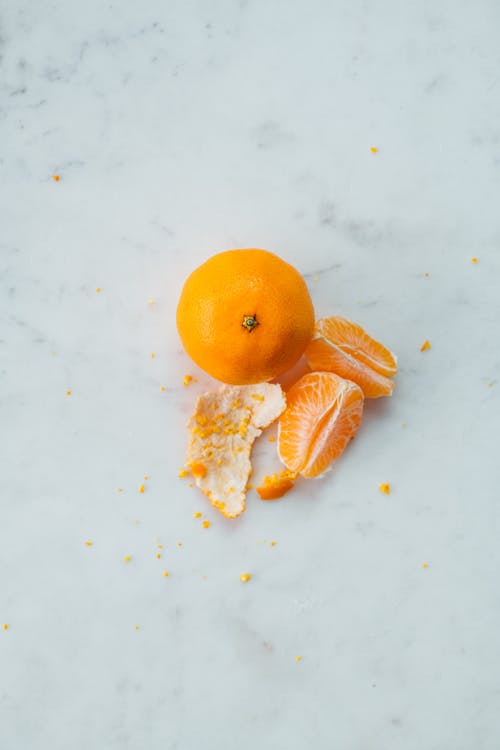 整个水果和皮肤去皮的橙片 · 免费素材图片