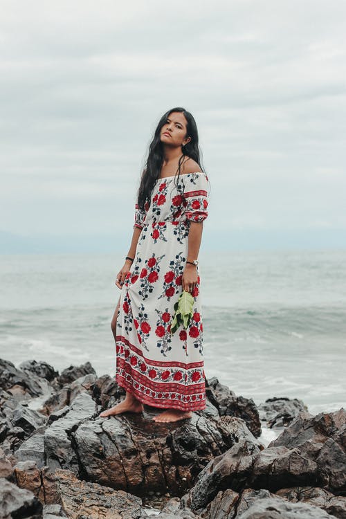 站在岩石海边的渴望民族女人 · 免费素材图片