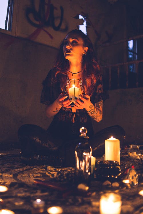 在仪式期间蜡烛之间的怪异女巫 · 免费素材图片