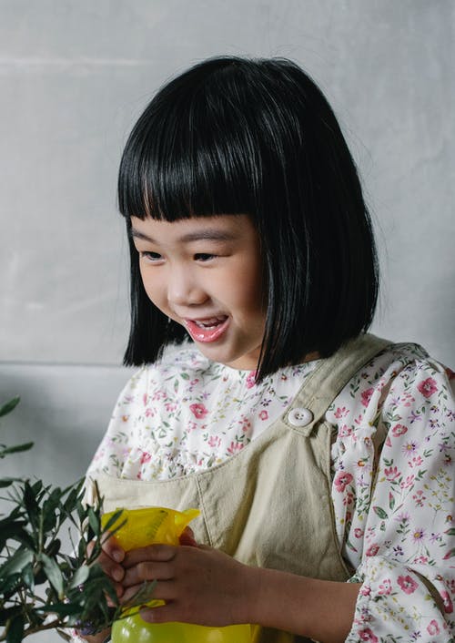 可爱的小女孩，喷涂绿色的植物 · 免费素材图片