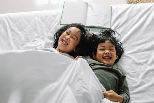 快乐的民族孩子在床上开心 · 免费素材图片