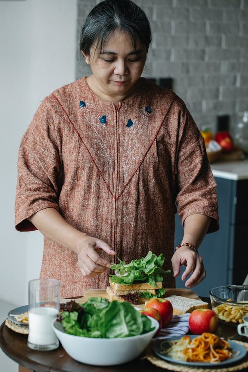 在家烹调三明治的亚裔资深妇女 · 免费素材图片