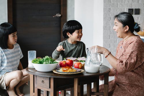 亚洲女人和可爱的孩子一起吃早餐 · 免费素材图片