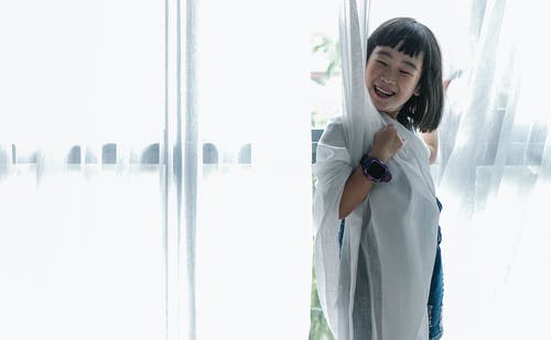 微笑与窗帘的亚洲女孩覆盖 · 免费素材图片