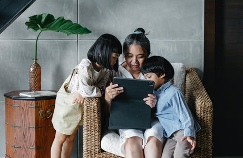 母亲带着孩子一起使用平板电脑 · 免费素材图片