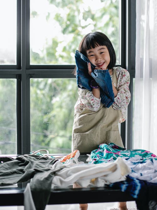 快乐的民族孩子在家里选择衣服 · 免费素材图片