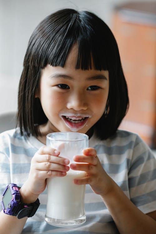 杯牛奶的快乐亚洲女孩 · 免费素材图片
