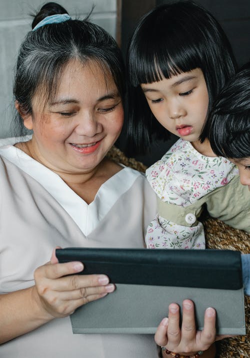 微笑的祖母和孩子们使用平板电脑 · 免费素材图片