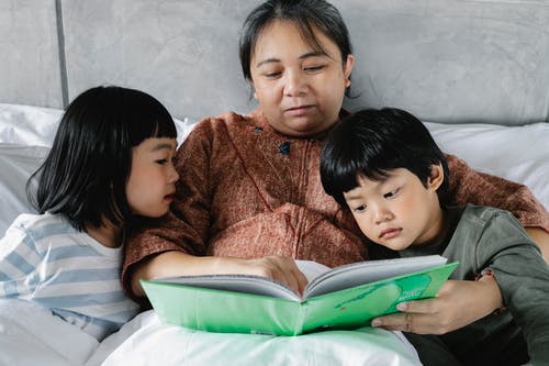 有孩子的亚洲祖母阅读书 · 免费素材图片