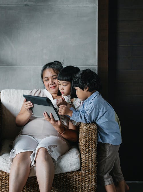 亚洲祖母和孩子在家中使用平板电脑 · 免费素材图片