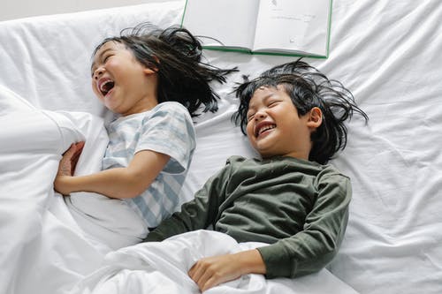 性格开朗的亚洲孩子在床上开心 · 免费素材图片