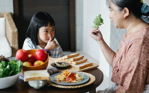 有孙女的高级妇女在桌上用食物 · 免费素材图片