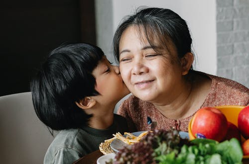 亚洲小男孩在脸颊上亲吻祖母 · 免费素材图片