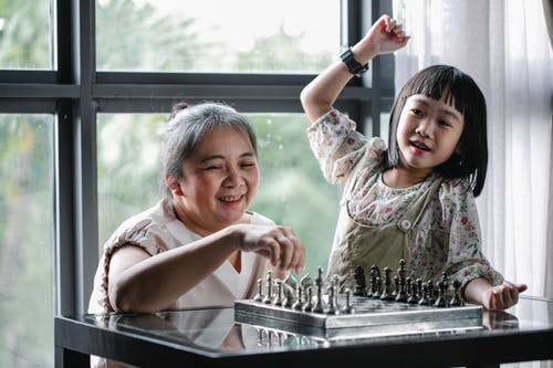 有在家下棋的逗人喜爱的孙女的快乐的资深种族妇女 · 免费素材图片