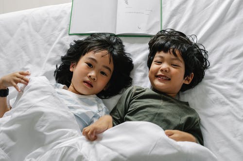 亚洲儿童躺在床上 · 免费素材图片