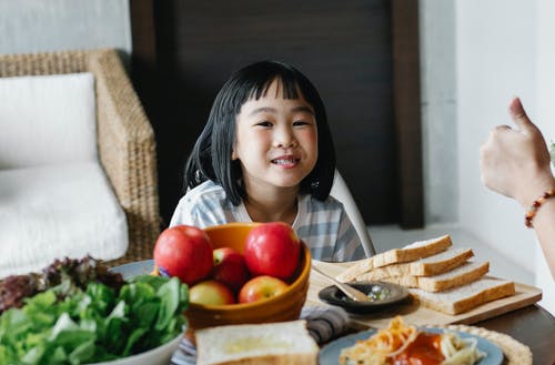 微笑小族裔孩子在家里吃美味的午餐 · 免费素材图片