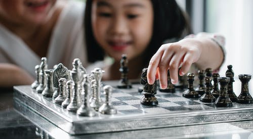 裁剪与父母下棋的小女孩 · 免费素材图片