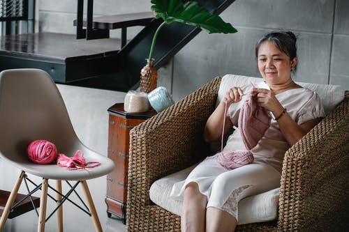 编织在柳条扶手椅上轻松族裔女人 · 免费素材图片