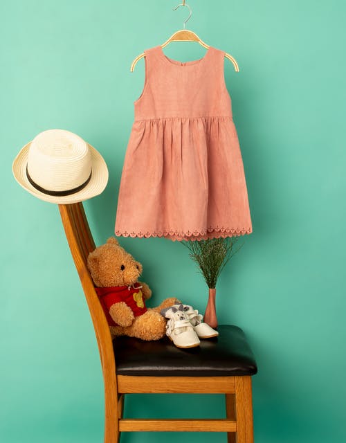 女孩的时髦礼服在玩具附近涉及绿色背景 · 免费素材图片