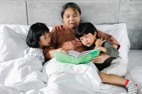 族裔母亲和孩子一起读童话 · 免费素材图片