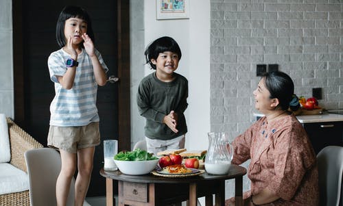 性格开朗的亚洲孩子在厨房里玩 · 免费素材图片