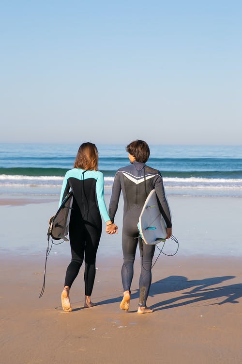 男人和女人在海滩上行走 · 免费素材图片