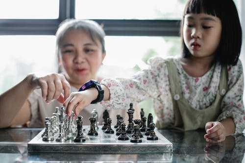 母亲和女儿下棋 · 免费素材图片