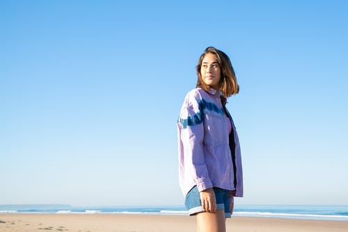站在海滩上的蓝色牛仔外套的女人 · 免费素材图片